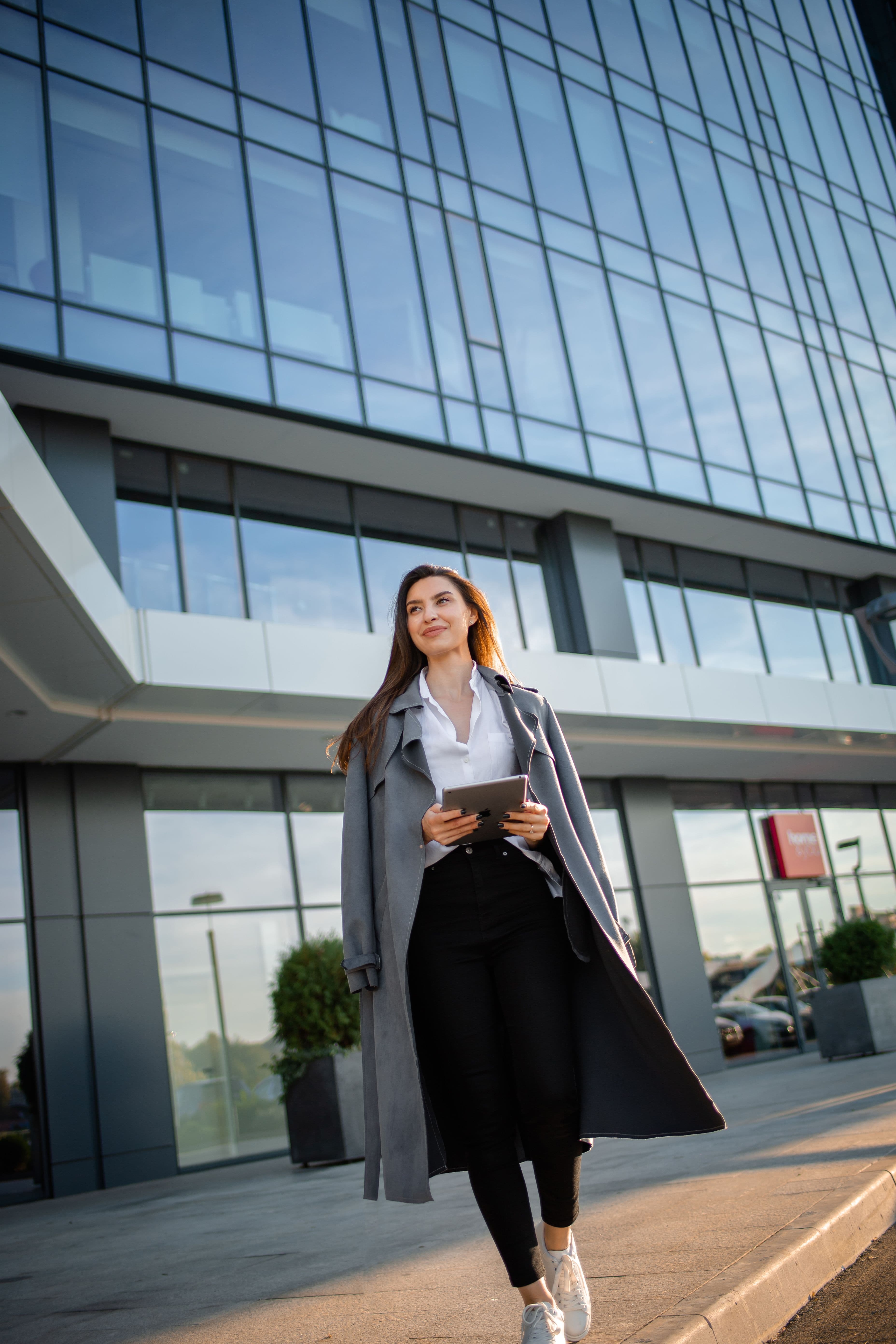 A professional walking outside a modern office building